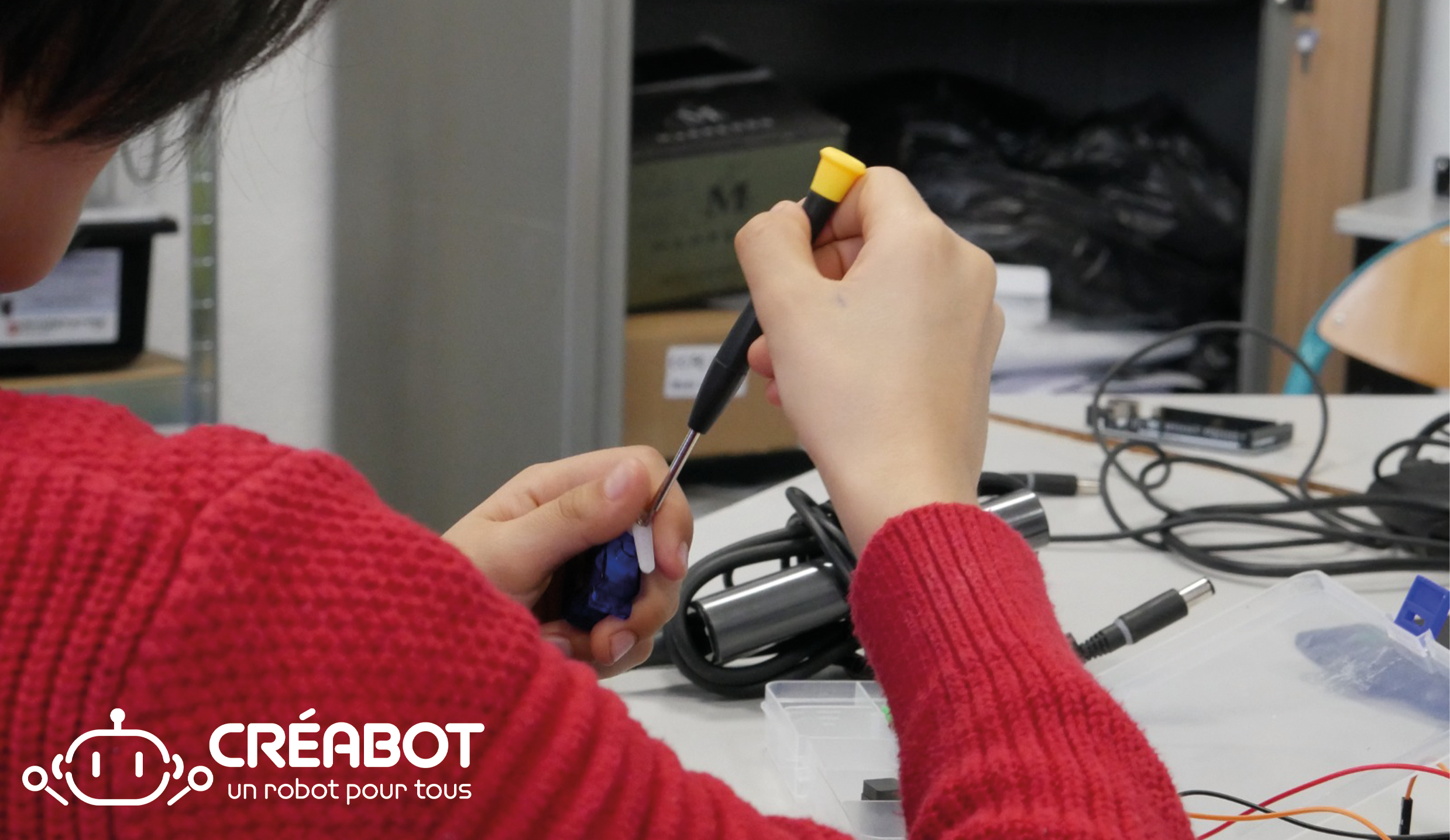 Un enfant participant au club de robotique organisé par Savoirs Vivants qui monte un robot