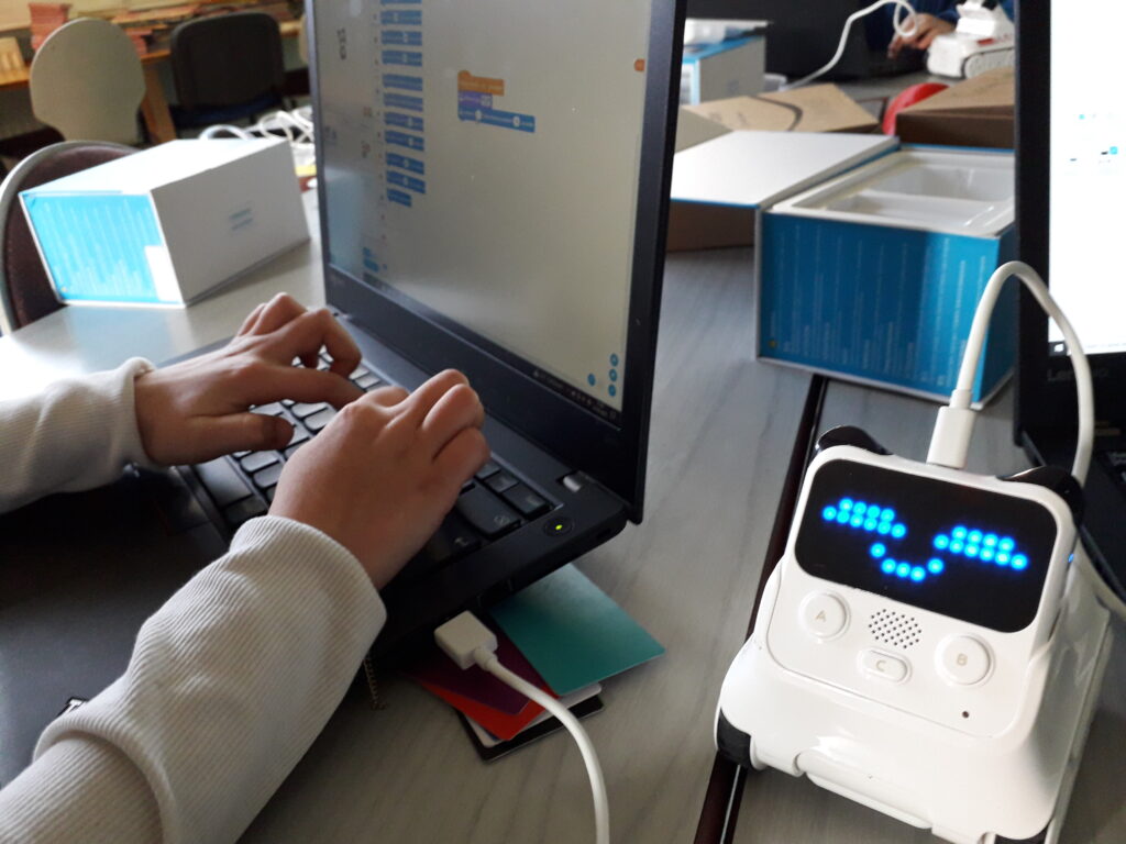 Enfant apprenant la programmation d'un robot Codey Rocky dans un atelier de médiation numérique