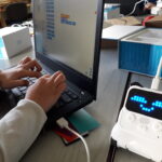 Enfant apprenant la programmation d'un robot Codey Rocky dans un atelier de médiation numérique